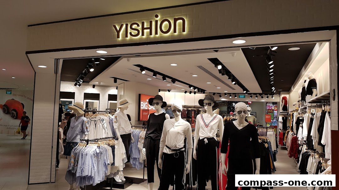 The entrance of a YISHION clothing store with mannequins displaying outfits and racks of clothes.