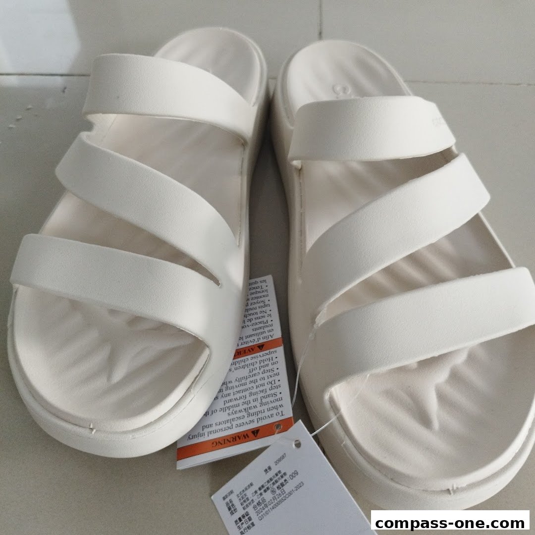 A pair of white Crocs sandals with two straps across the top.