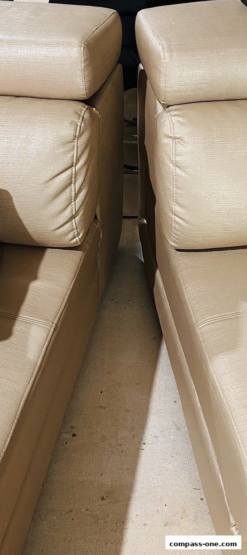 Close-up view of the textured fabric and stitching on two beige sofas.