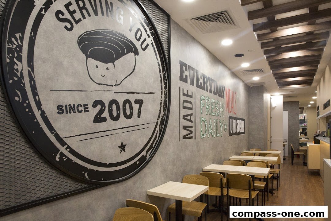 Interior of a sushi restaurant with tables, chairs, and wall art.