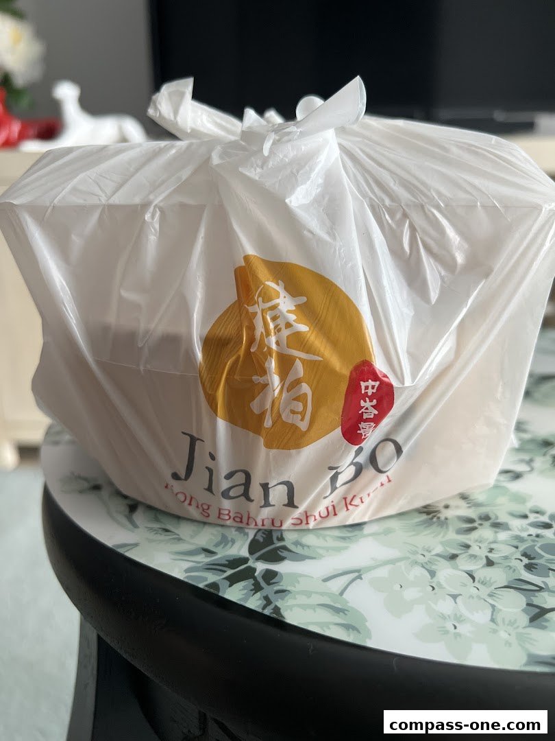 A plastic bag with the Jian Bo Shui Kueh logo containing takeout food.