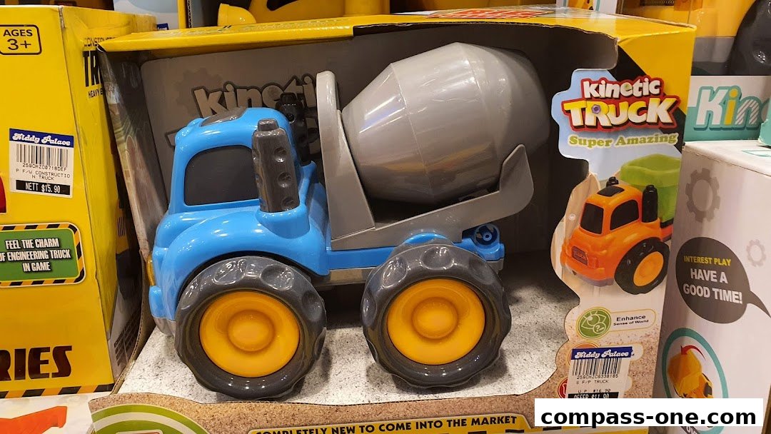 A blue toy cement mixer truck is displayed in its packaging, with other toys visible.