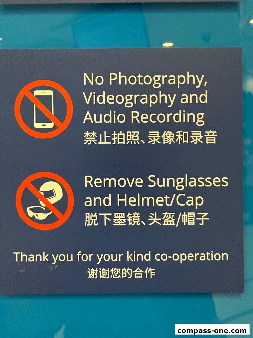 A sign with rules about no photography, videography, audio recording, and removing sunglasses and headwear.