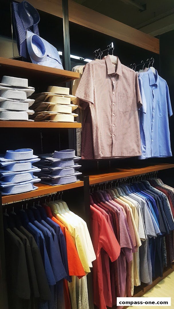 A display of neatly folded and hung men's shirts in various colors and patterns.
