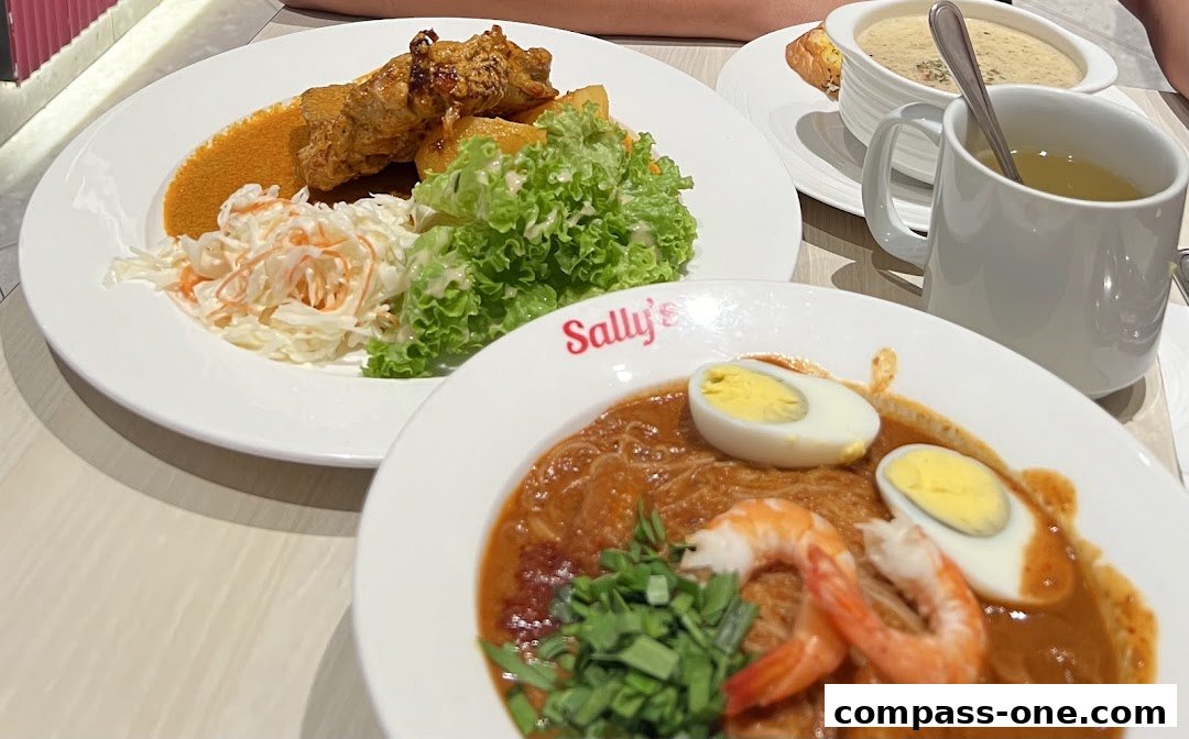 A close-up of two delicious meals from Sally's, featuring noodles with shrimp and egg, and fried chicken with salad.