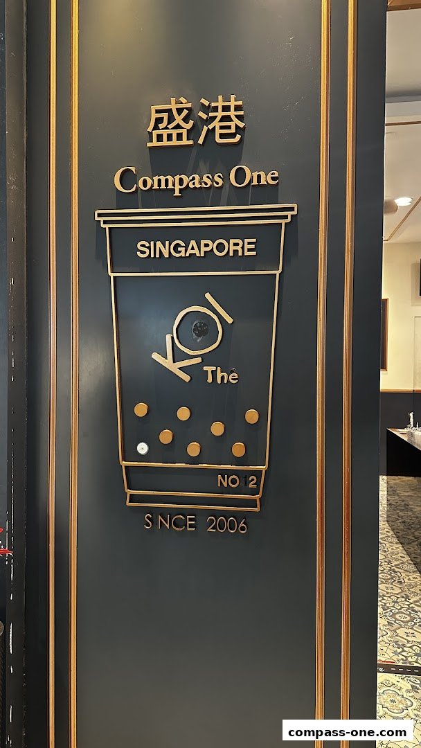 The entrance of KOI Thé at Compass One, featuring the brand's logo and establishment year.