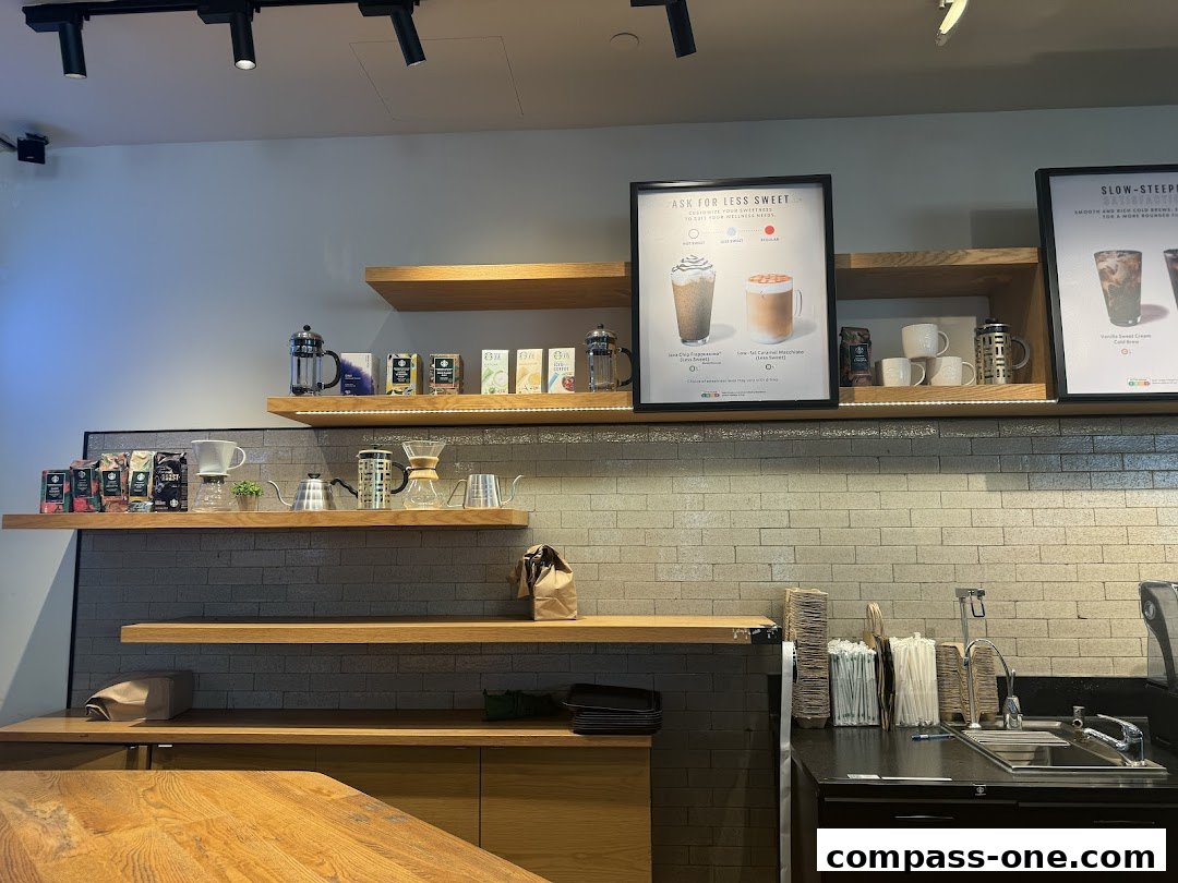 Interior view of a Starbucks coffee shop with shelves displaying coffee brewing equipment and drinks.