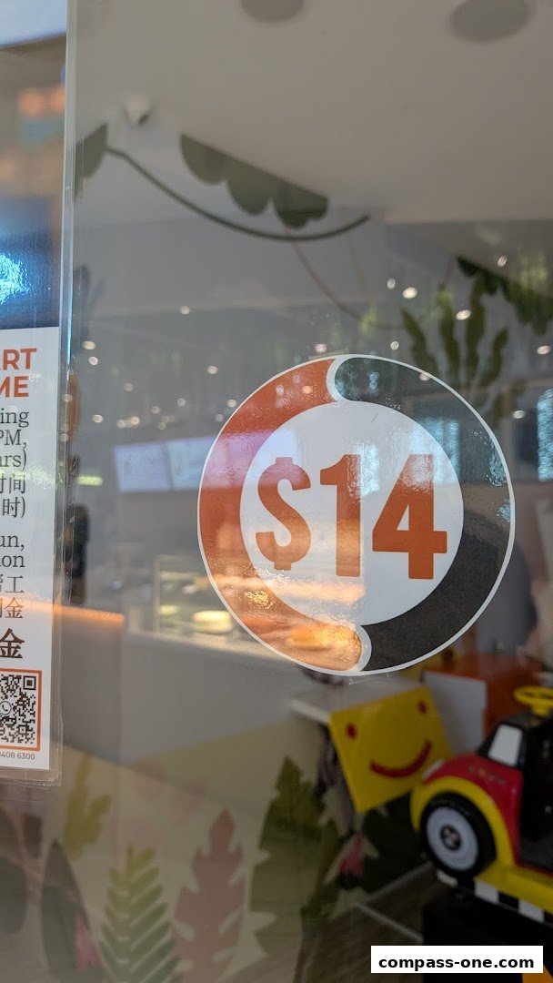 A sticker with '$14' is displayed on a glass surface, with a shop interior visible behind it.