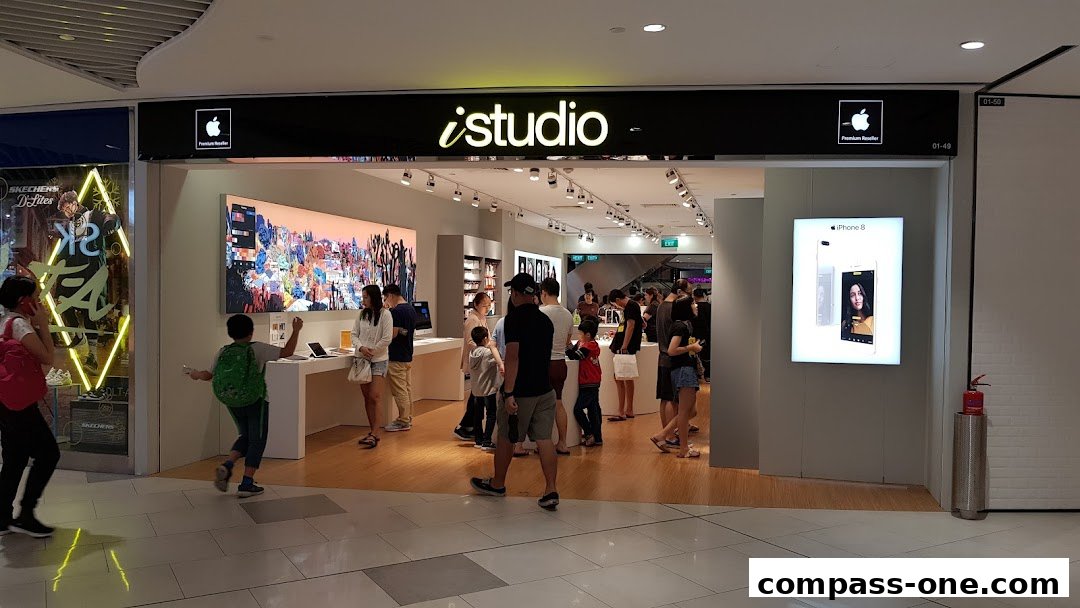 The entrance of an iStudio Apple Premium Reseller shop with customers browsing.