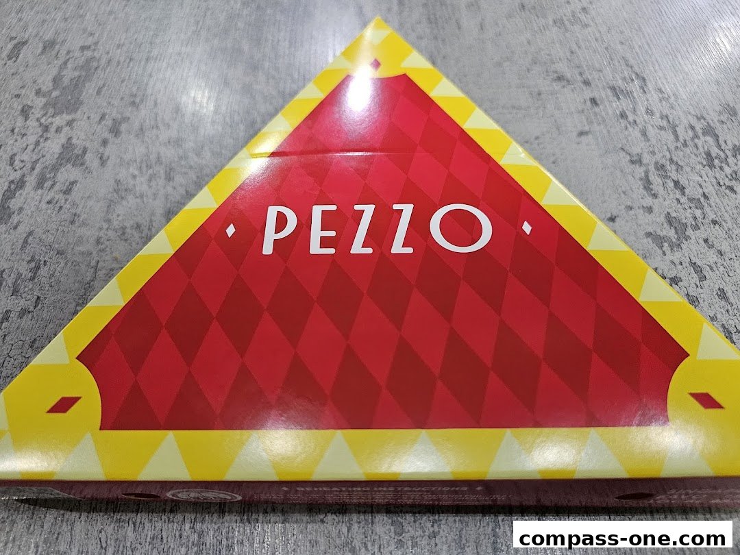 A triangular pizza box with the Pezzo logo in white on a red and yellow diamond pattern.