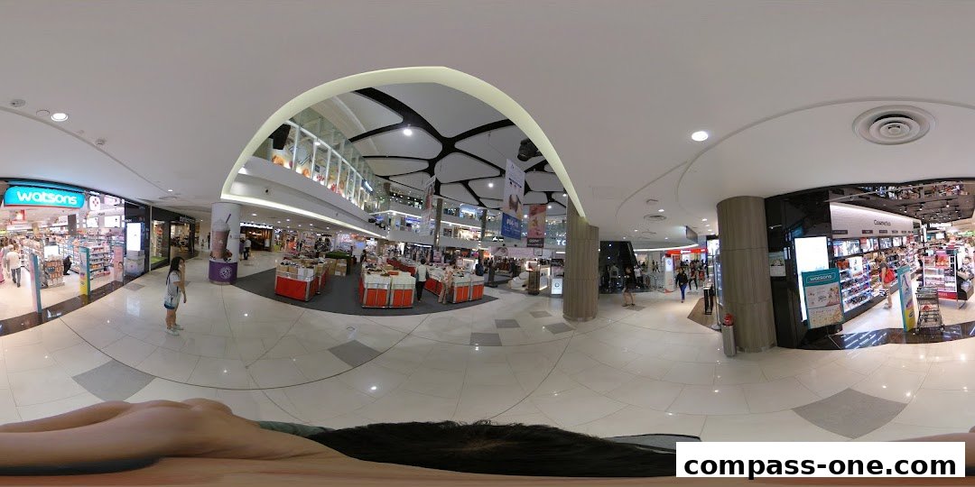 A panoramic view of a shopping mall interior, featuring Watsons and other retail stores.