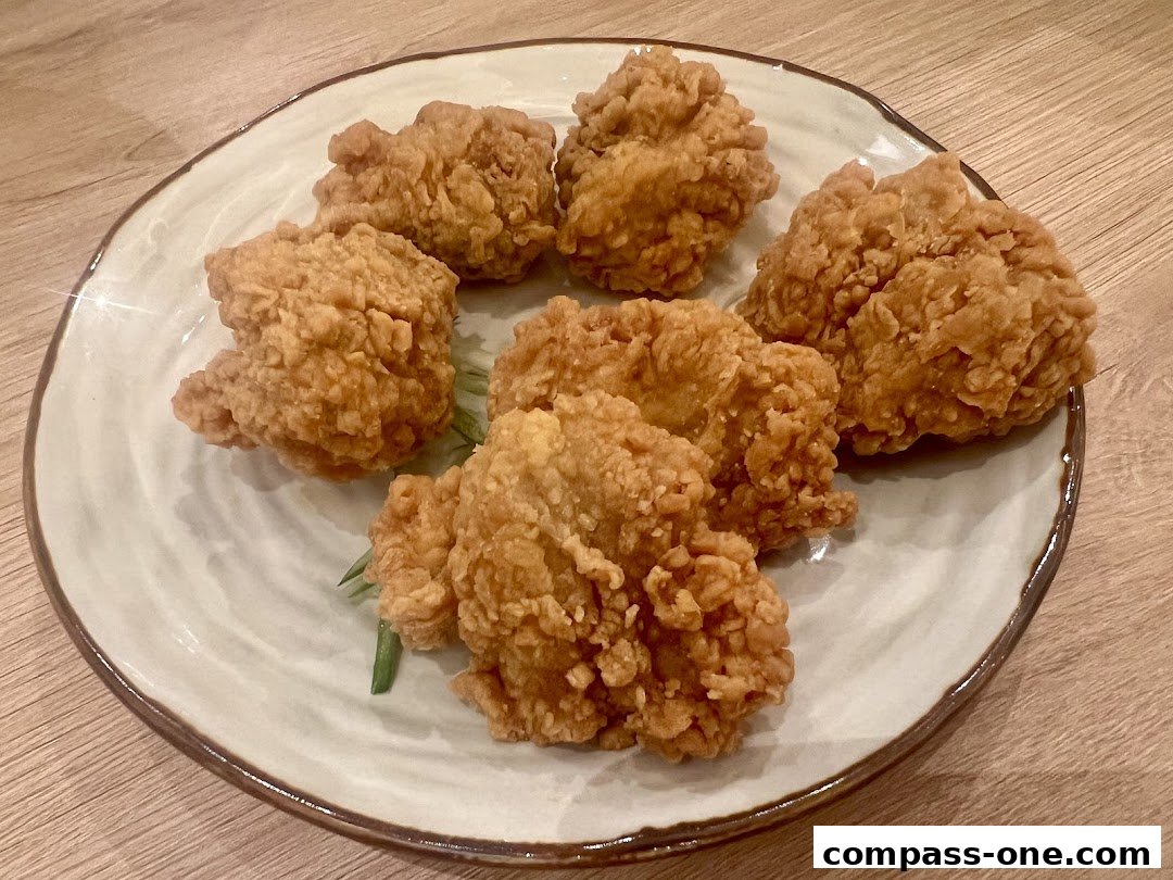 A plate of crispy, golden-brown fried chicken pieces served on a light blue speckled plate.