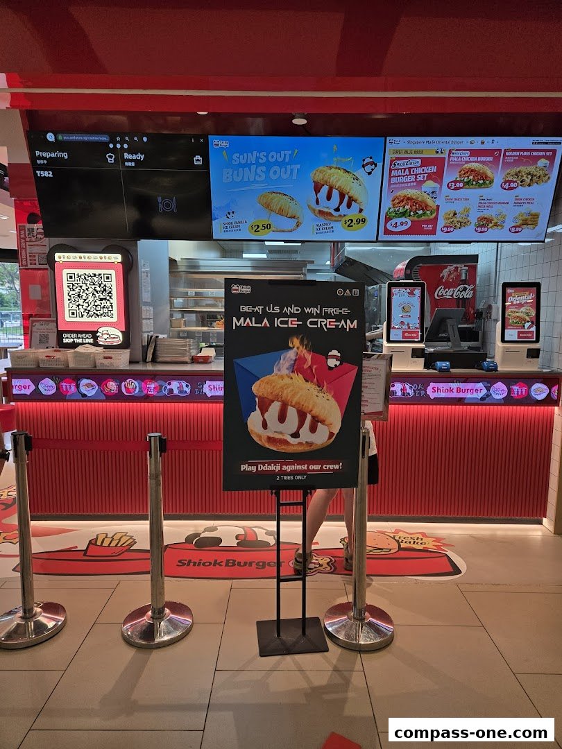 The Shiok Burger counter with digital menus displaying burgers and ice cream, and a promotional sign.