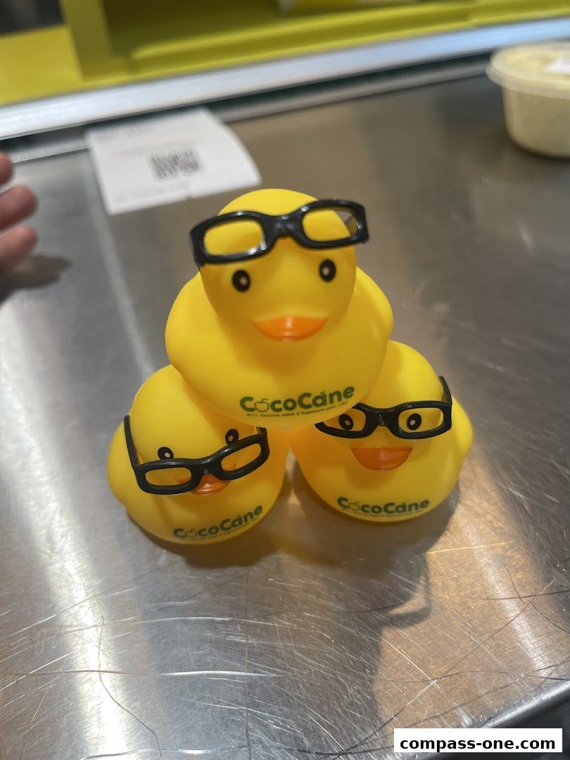 Three yellow rubber ducks wearing glasses are stacked on a counter.