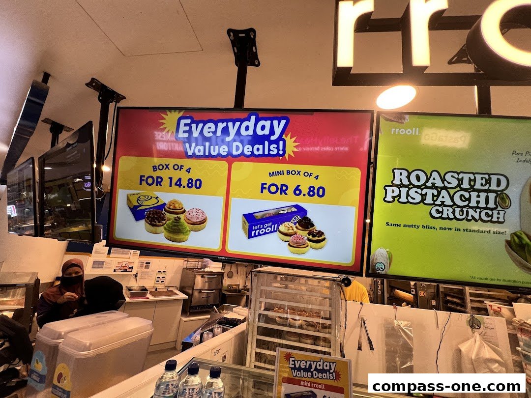 Digital screens display value deals for rrooll cinnamon rolls and a roasted pistachio crunch flavor.