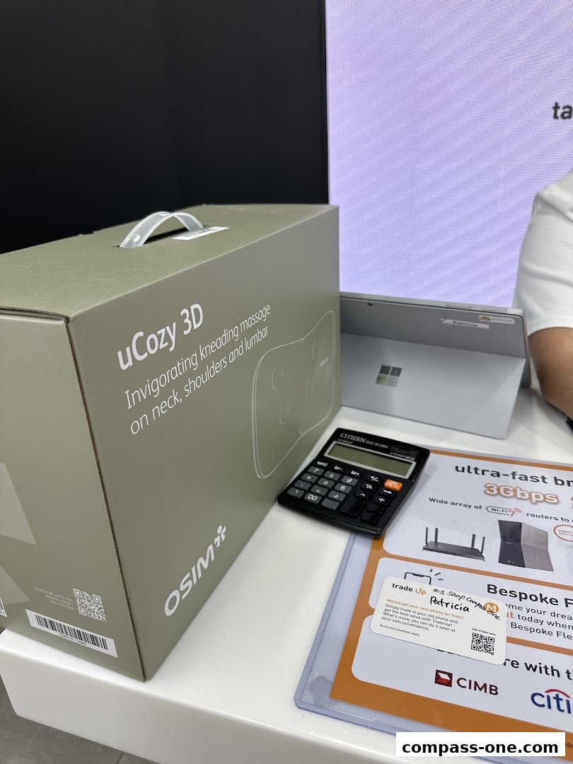OSIM uCozy 3D massager box, calculator, and promotional flyers on a display counter.