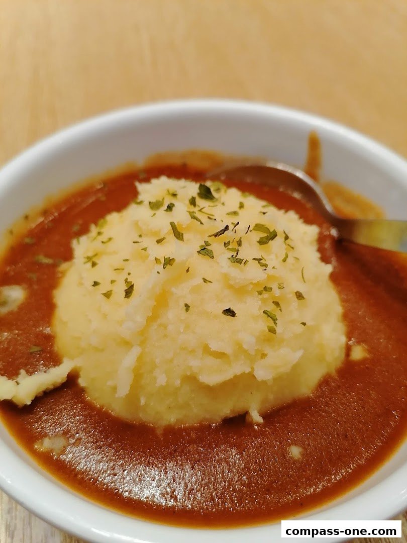 A close-up shot of a Pepper Lunch dish featuring mashed potatoes and a rich brown sauce.