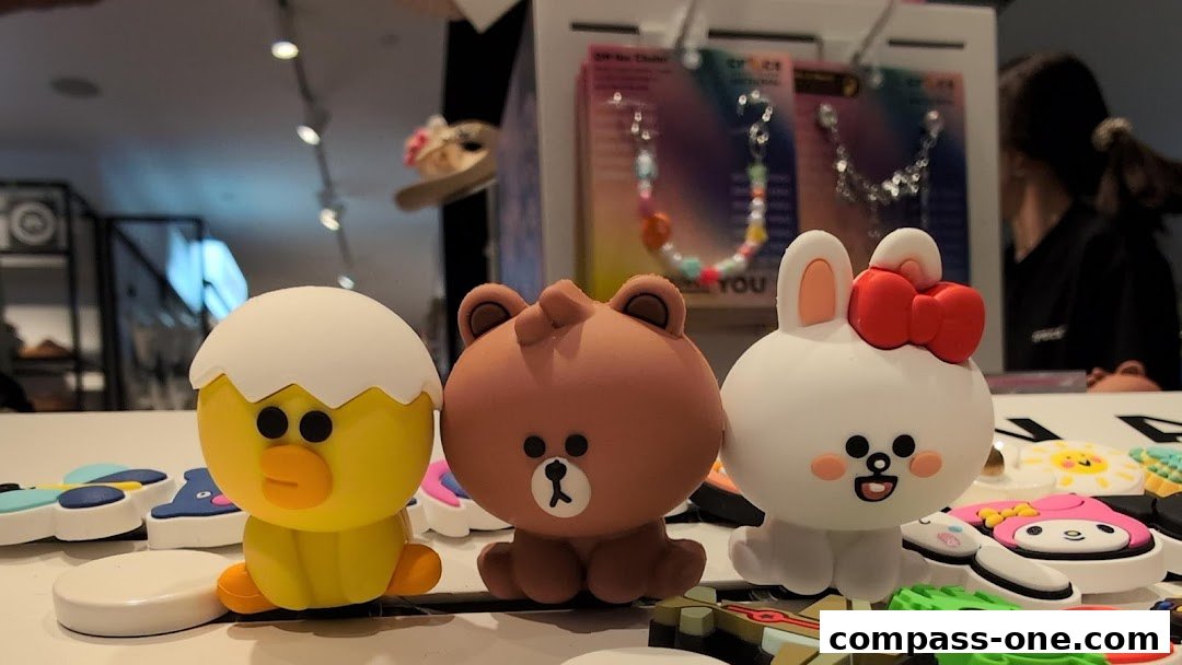 Cute character charms for Crocs shoes displayed on a counter.