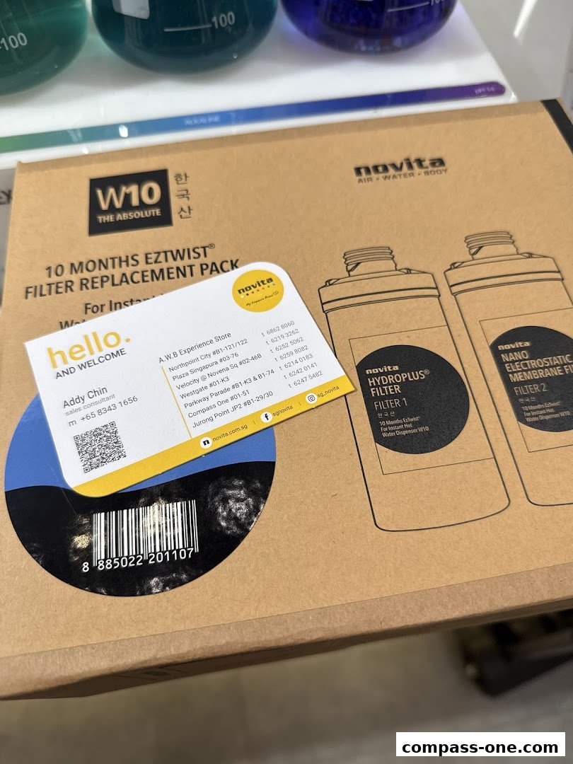 A Novita filter replacement pack with a business card and laboratory beakers in the background.