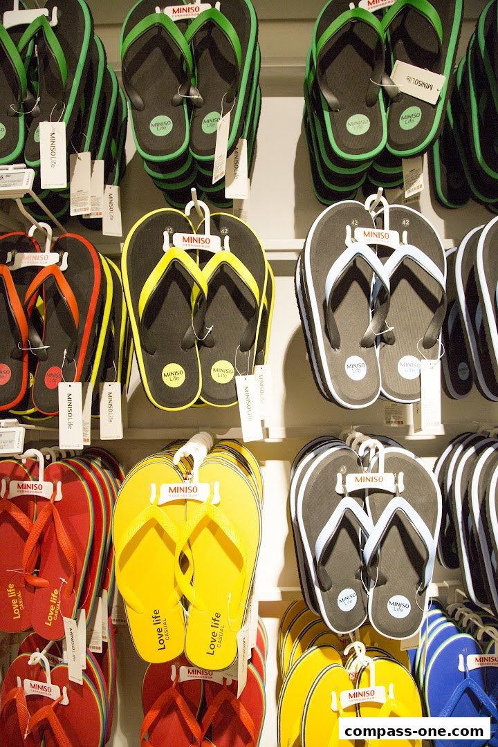 A wall display of colorful flip-flops, featuring various colors and styles.