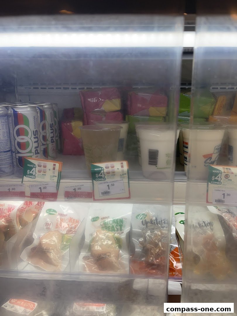 A refrigerated display case at 7-Eleven showing packaged chicken breasts and drinks.