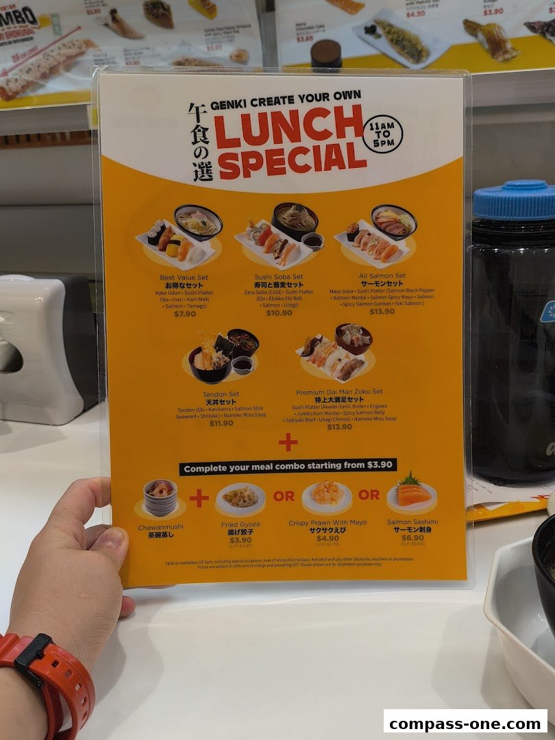 A person holds a Genki Sushi lunch special menu featuring various sushi and noodle sets.