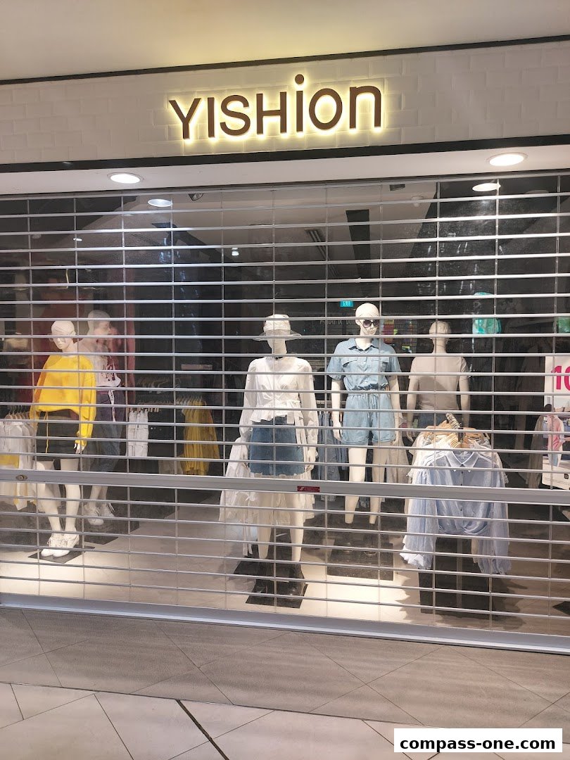 YISHION store front with mannequins displaying casual outfits behind a metal security gate.