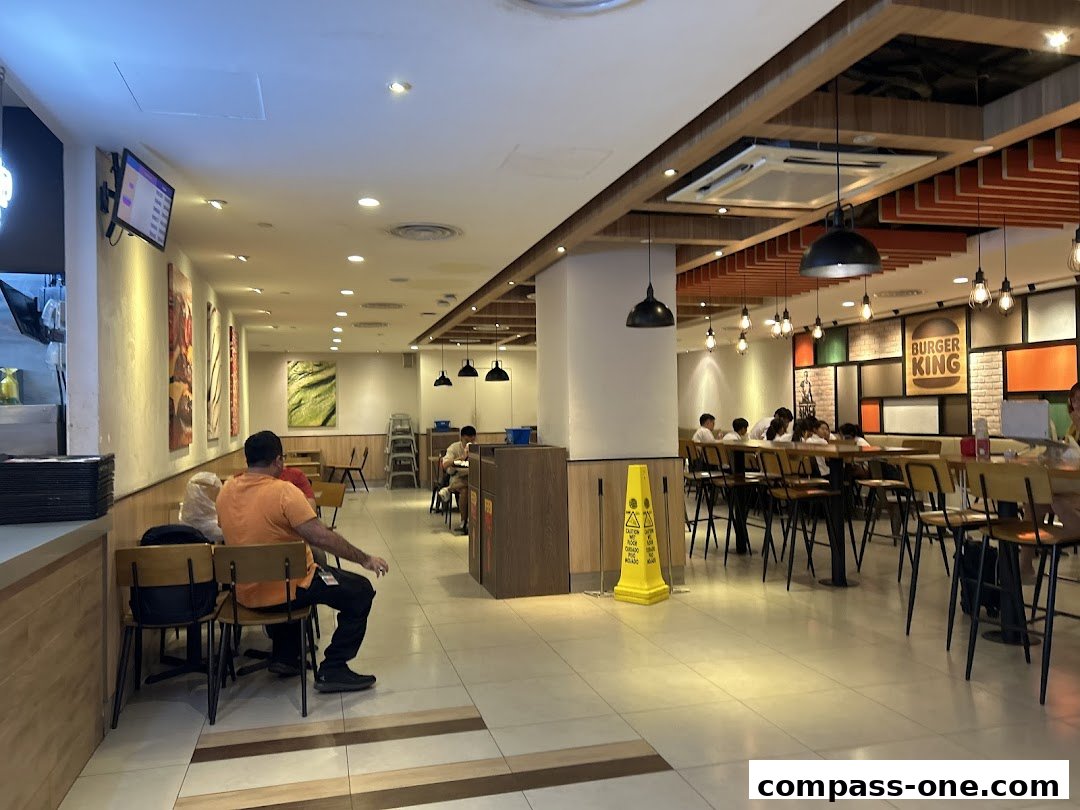 Interior view of a Burger King restaurant with customers seated at tables.