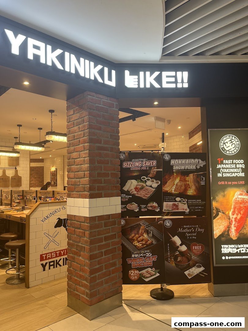 The entrance of Yakiniku Like restaurant with a prominent sign and promotional posters.