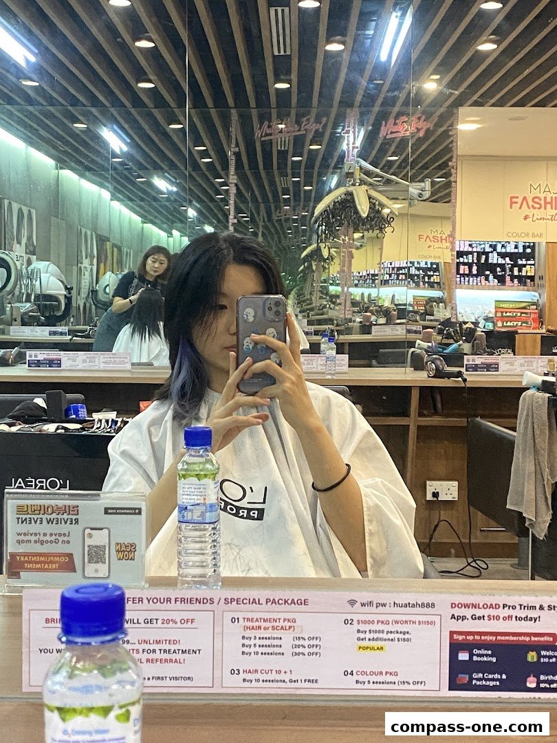 A person takes a selfie in a hair salon, showing the interior and a price list.