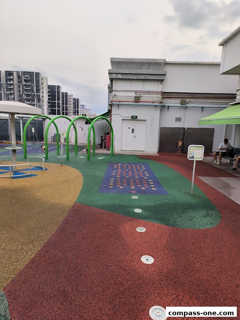 A colorful outdoor water playground with spray features and soft flooring.