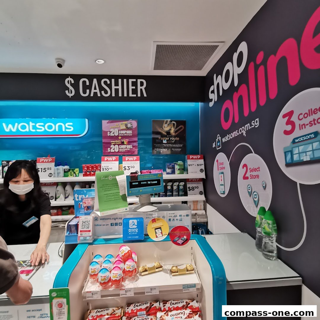 A Watsons cashier counter with a staff member and various products displayed, promoting online shopping.