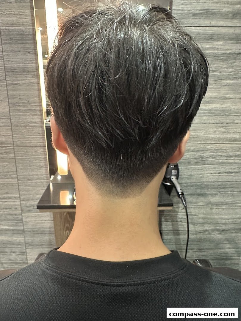 Back view of a person's head showing a neat haircut with a tapered neckline.