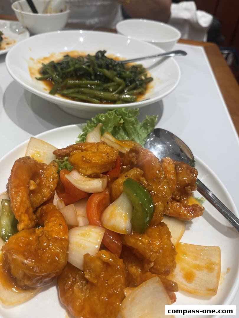 Two plates of delicious Asian cuisine, featuring sweet and sour shrimp and stir-fried vegetables.