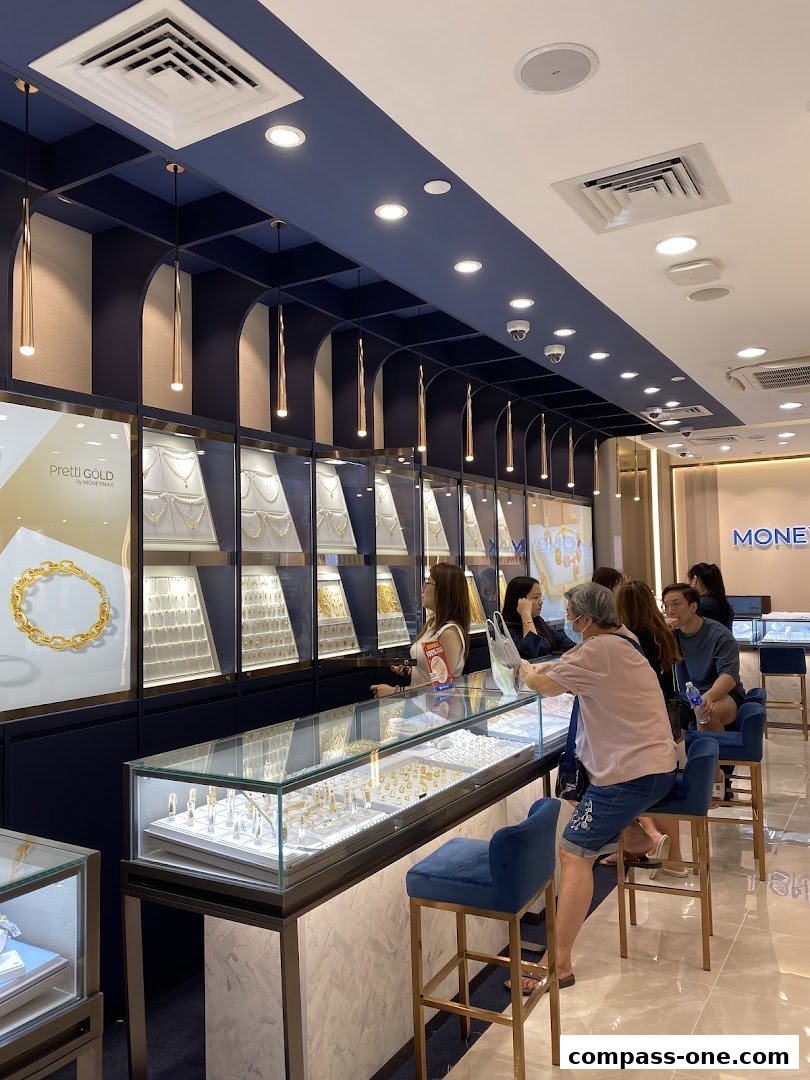 Customers browse jewelry displays in a well-lit, modern store with blue and gold accents.