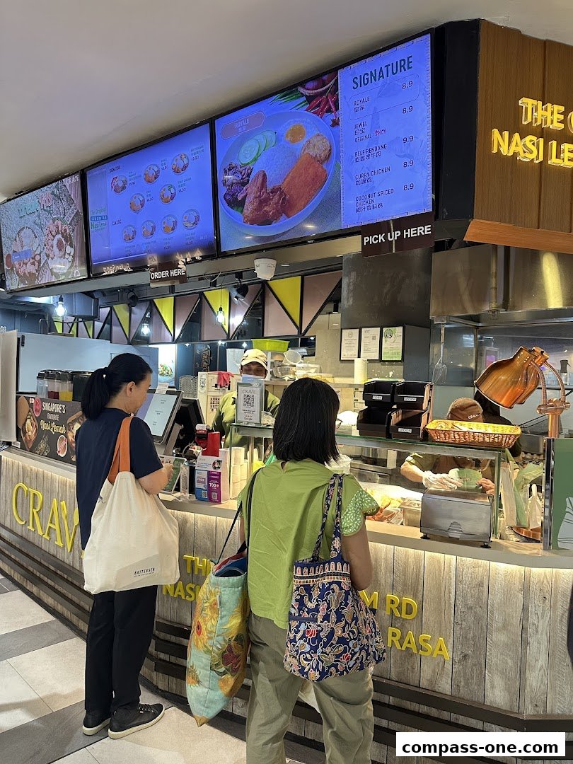 Customers ordering at a Nasi Lemak stall with digital menus displaying food items.
