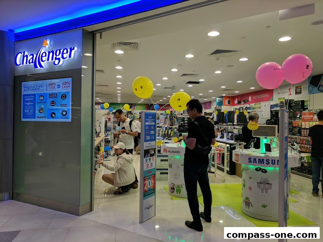 The entrance of a Challenger electronics store with customers browsing inside.