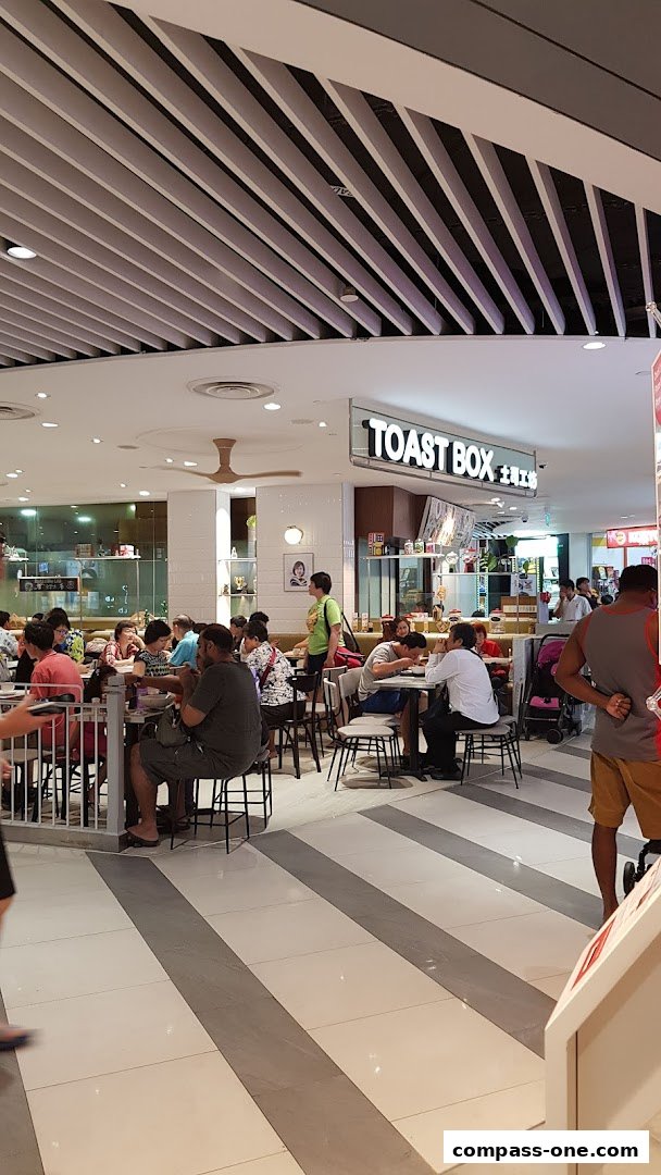 People dining at Toast Box restaurant with a busy atmosphere.