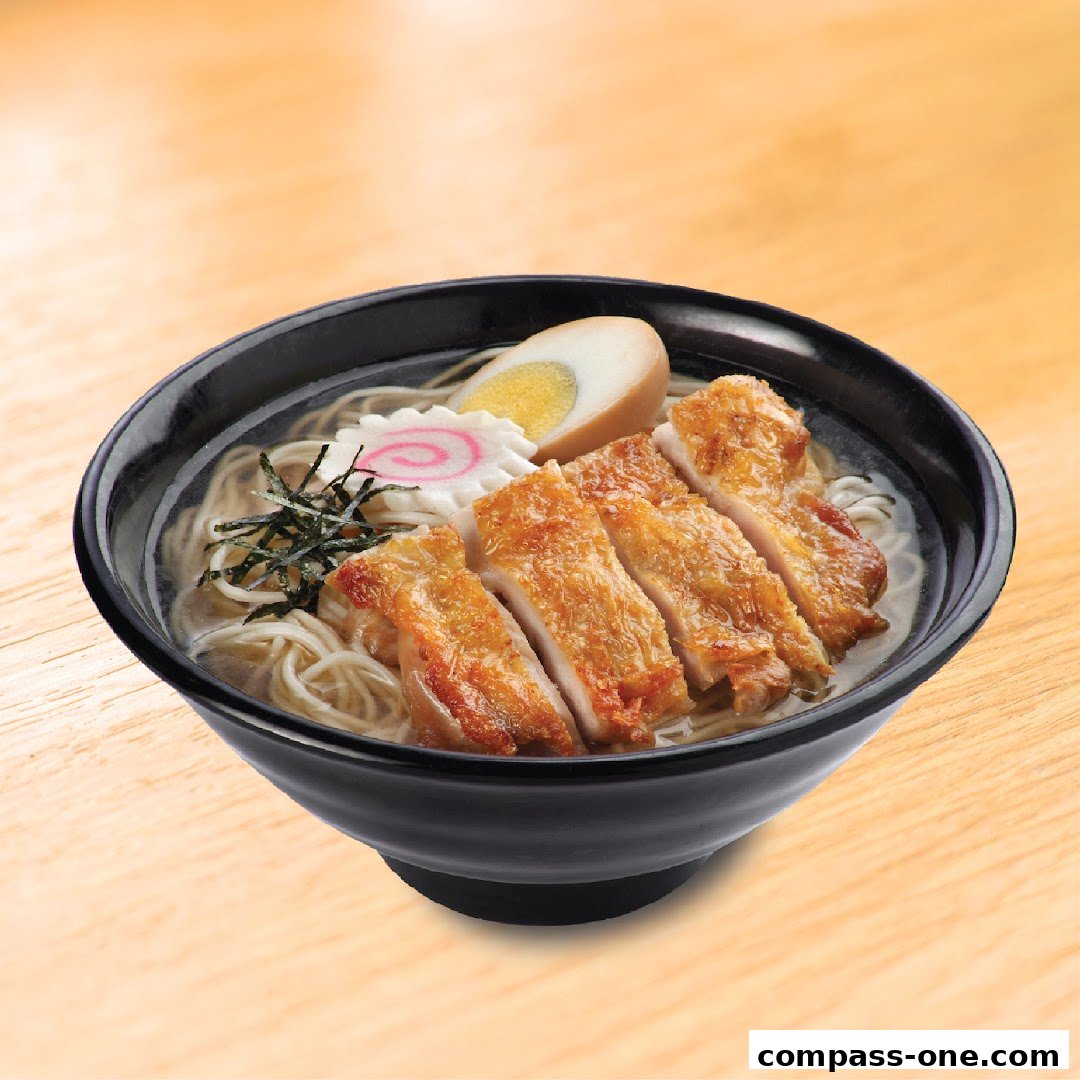 A close-up of a delicious bowl of ramen with grilled chicken and a soft-boiled egg.