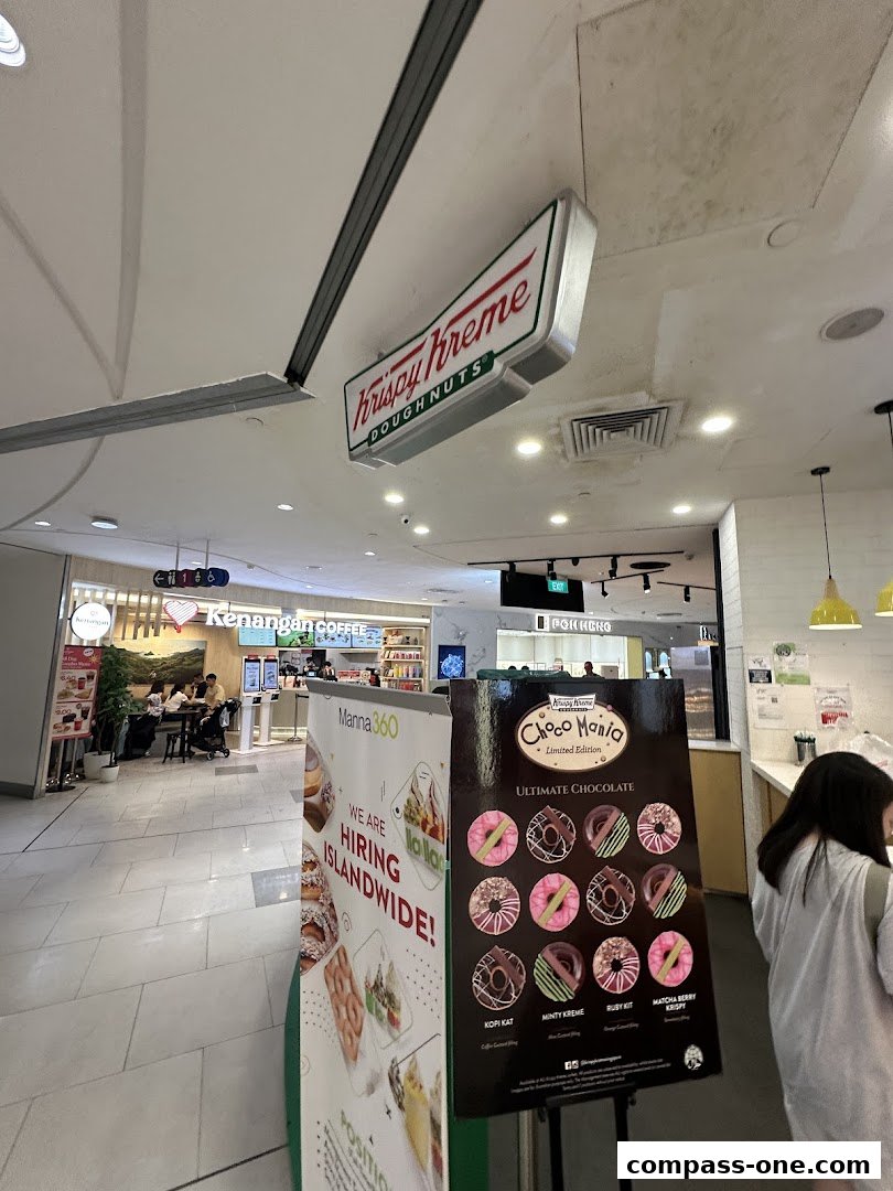 Krispy Kreme shop with a display of donuts and a hiring advertisement.