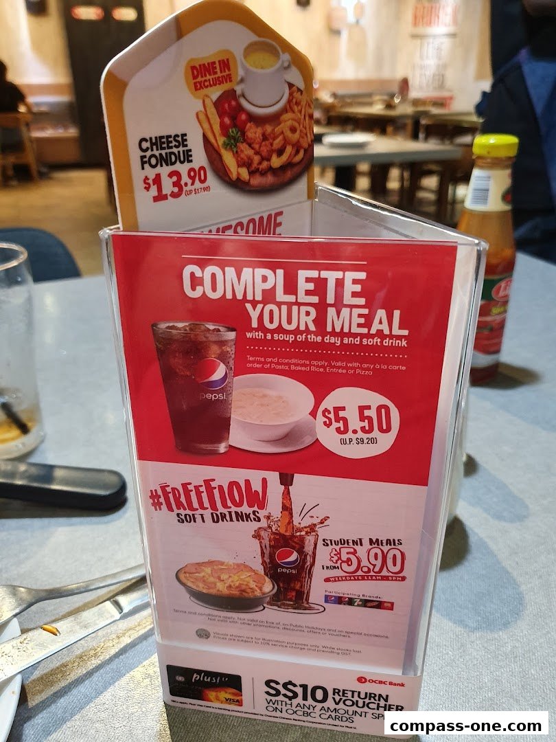 A menu display for Pizza Hut featuring cheese fondue, meal deals, and soft drink offers.