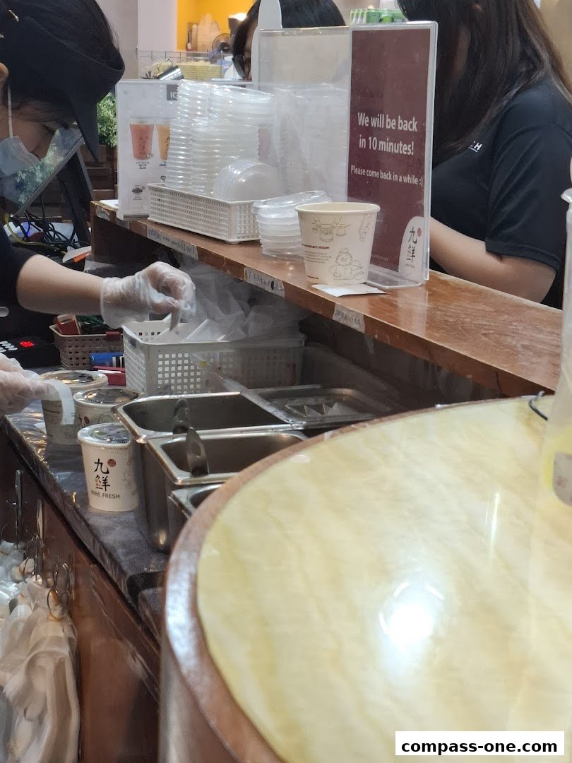 A counter at Nine Fresh Desserts Taiwan with staff preparing orders and a sign indicating a short break.