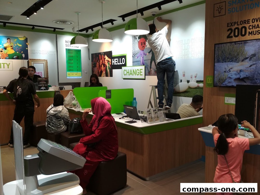 People are inside a brightly lit shop with green accents, some interacting with staff and displays.