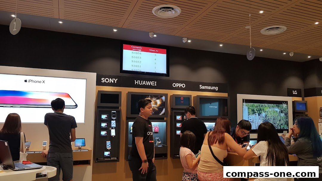 Customers browse phones at a Singtel Exclusive Retailer with displays from major brands.