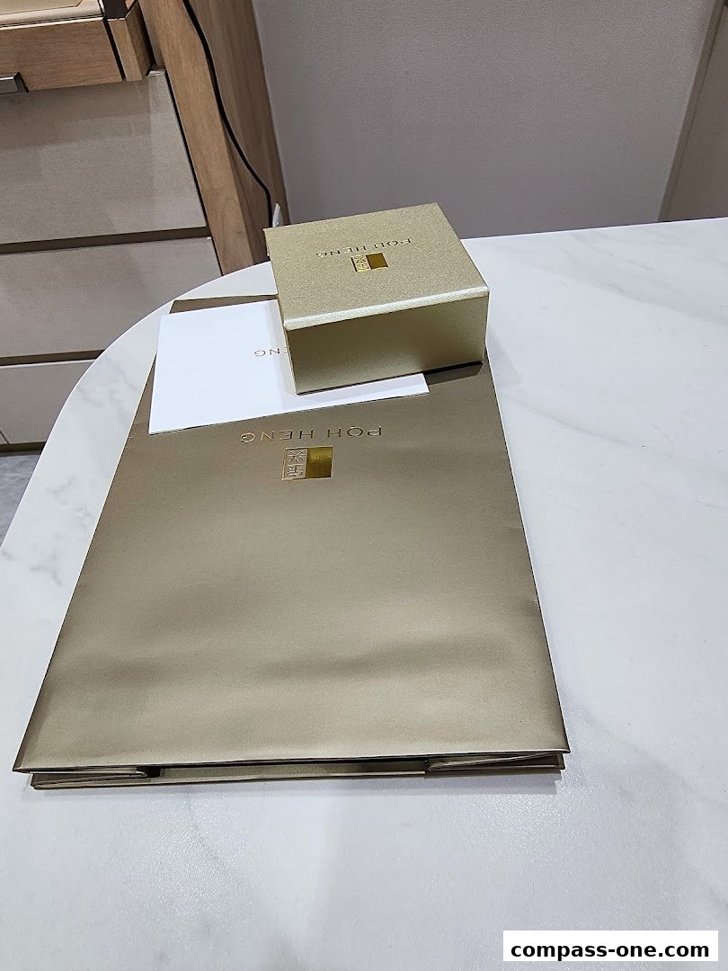 A gold jewelry box and shopping bag from Poh Heng Jewellery.