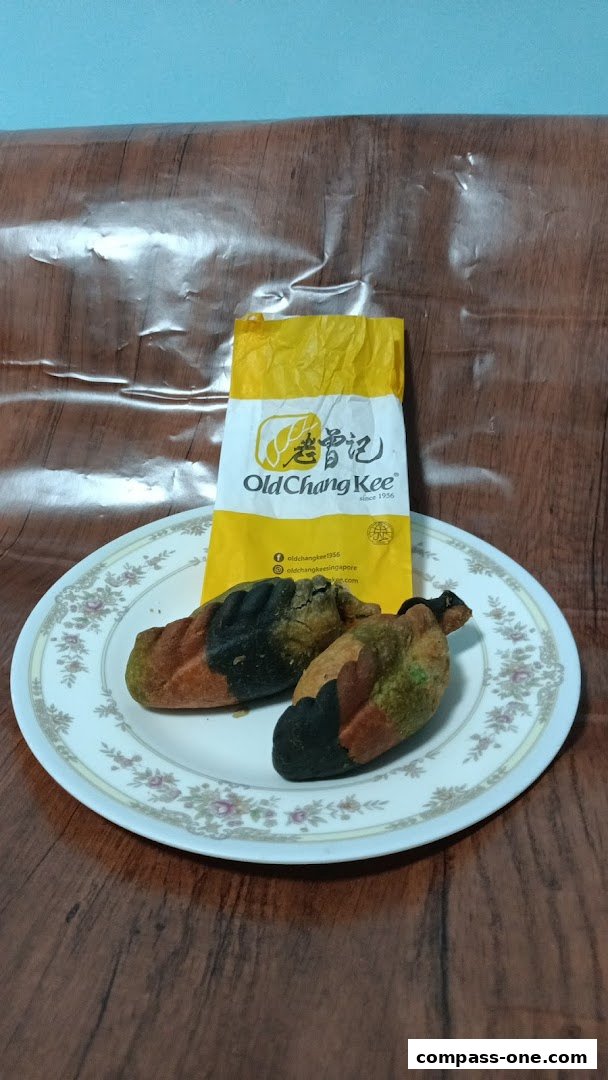 Two colorful pastries are displayed on a plate with an Old Chang Kee paper bag.