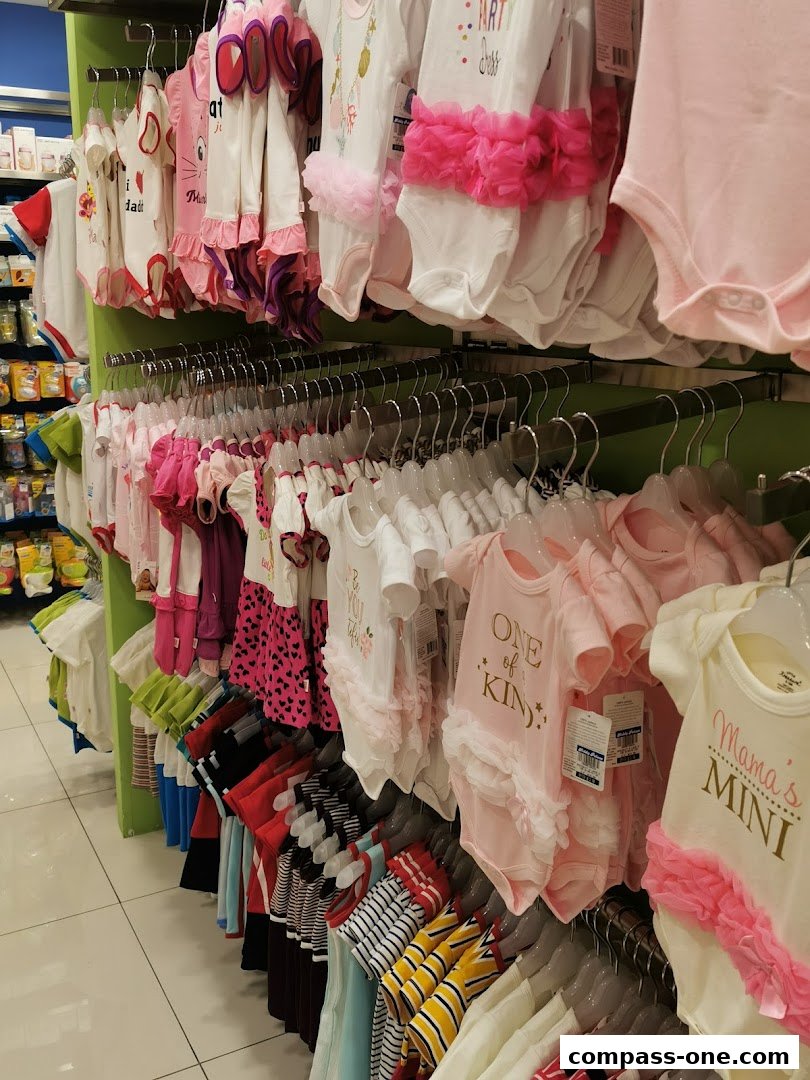 A display of cute baby onesies and outfits in various pastel colors and designs.