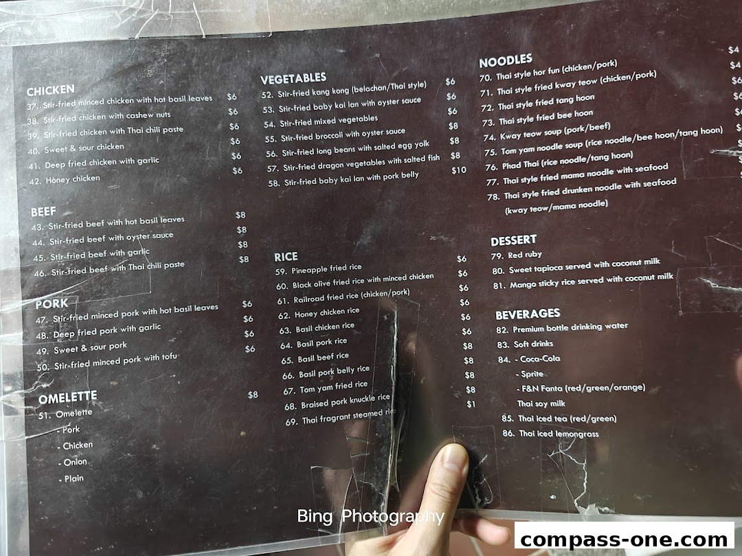 A close-up view of a Thai restaurant menu with various dishes and prices listed.