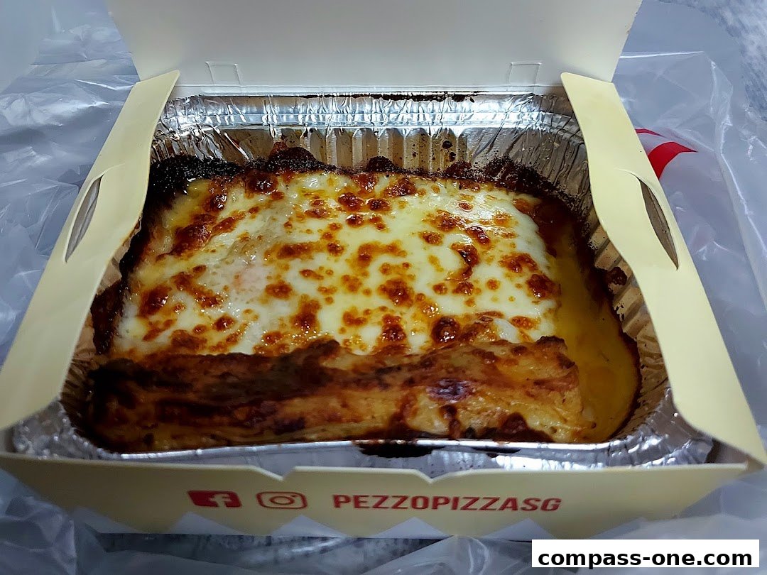A close-up shot of a delicious-looking lasagna in a takeaway box.