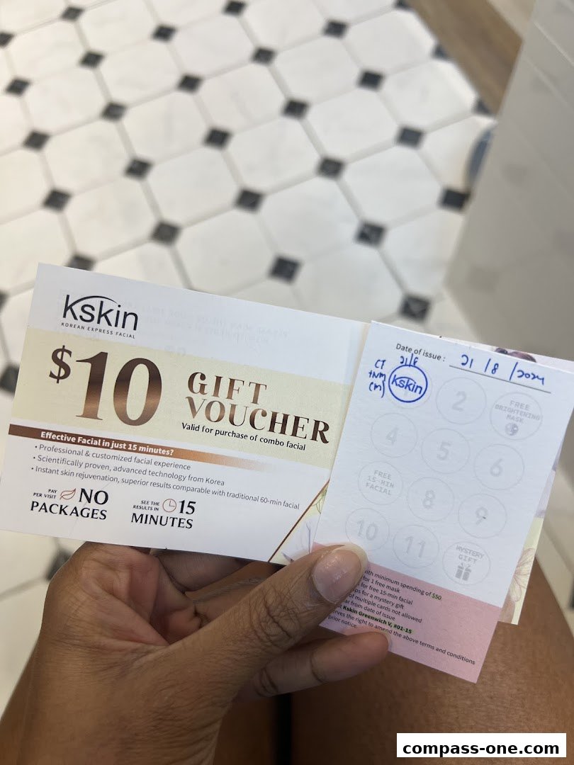 A hand holds a $10 gift voucher for Kskin Korean Express Facial.